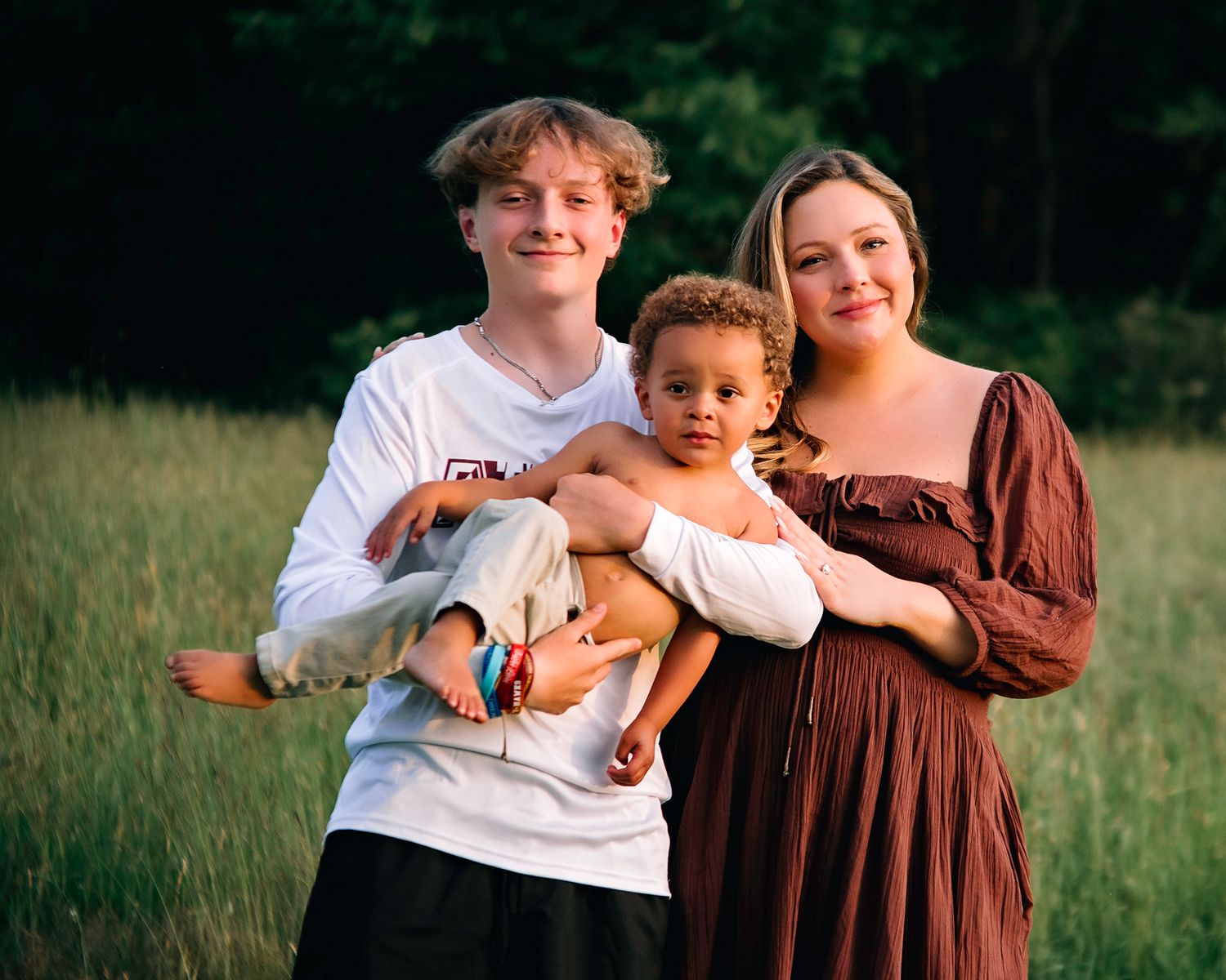 A playful image of a Teenage Boy and his Toddler Brother with their mom in their Westborough Family Photoshoot.