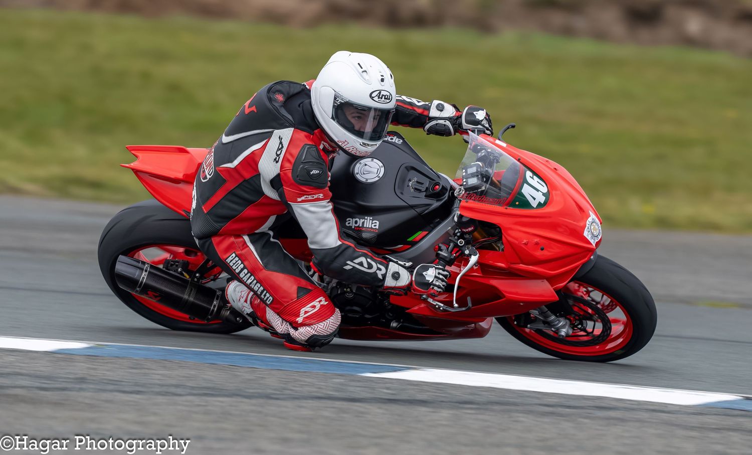 A red motorcycle number 46 powers through a corner