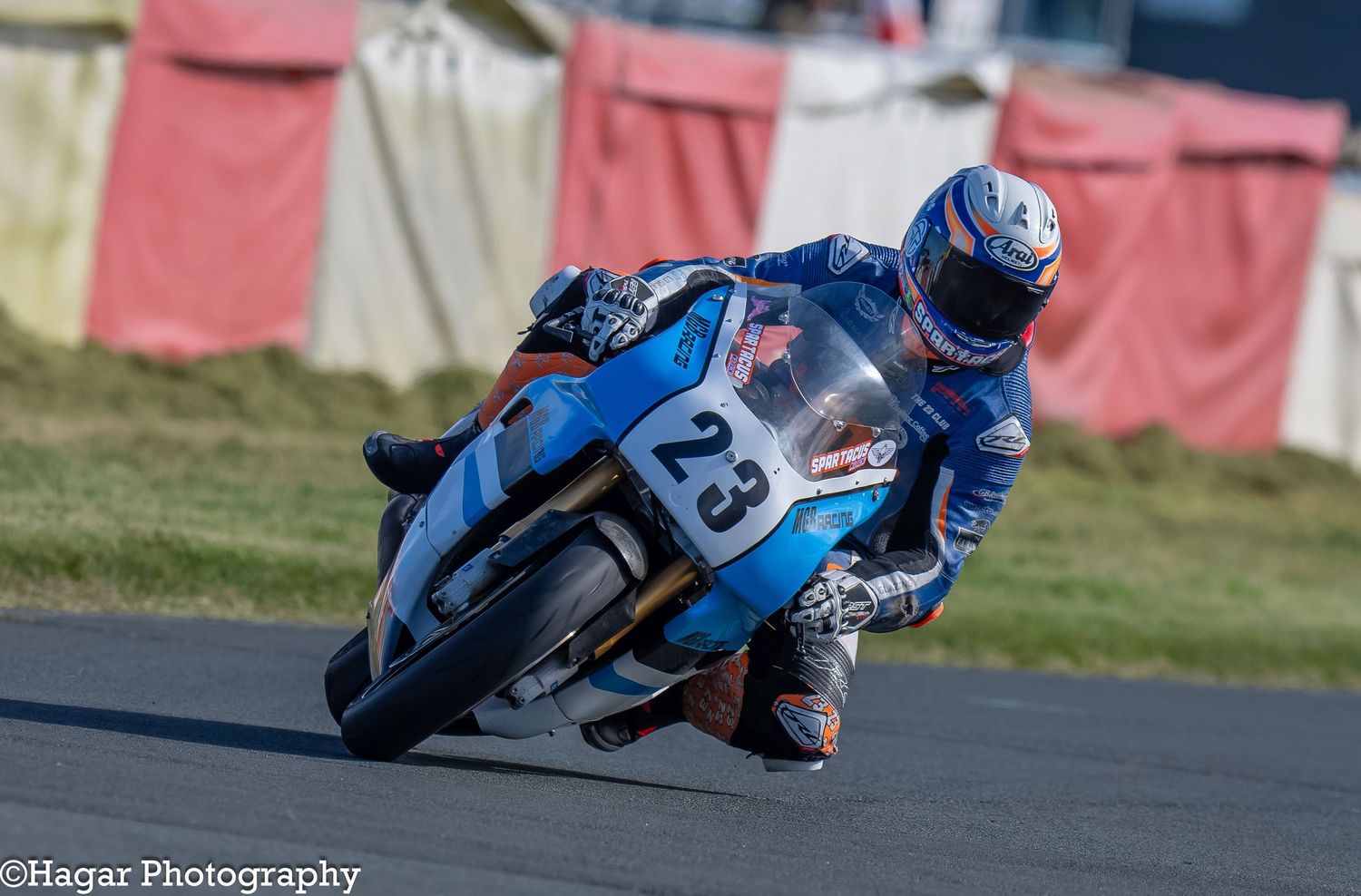 A blue motorbike number 23 driving through a sharp corner