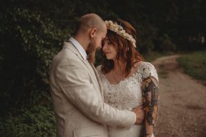 Intimate wedding portrait showing couple's tender moment on rustic path.