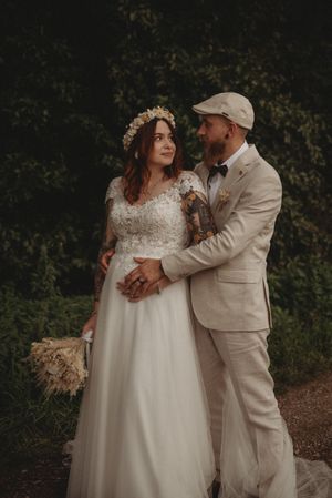 A romantic wedding portrait featuring vintage-inspired styling and natural surroundings.