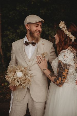 Joyful wedding moment captured with dried flowers and casual beige suit style.