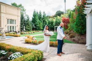 Beautiful garden wedding setting with manicured flower beds, stone pathways and ornate architecture on a sunny day.