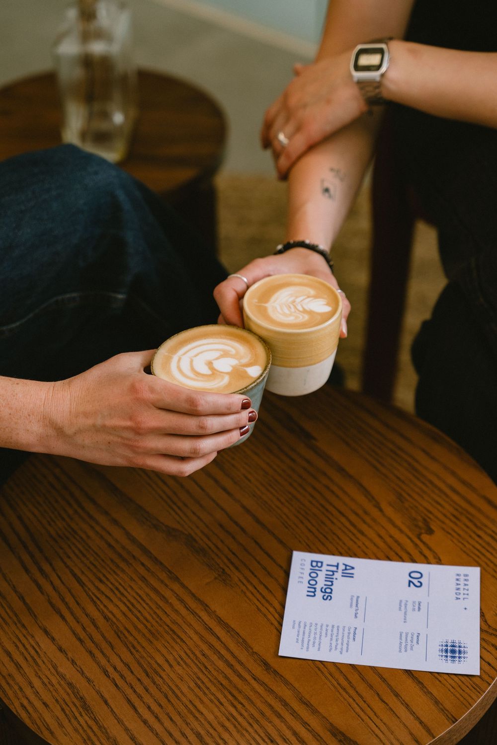 Lifestyle coffee photography in London showing two cups of beautiful latte art cheering