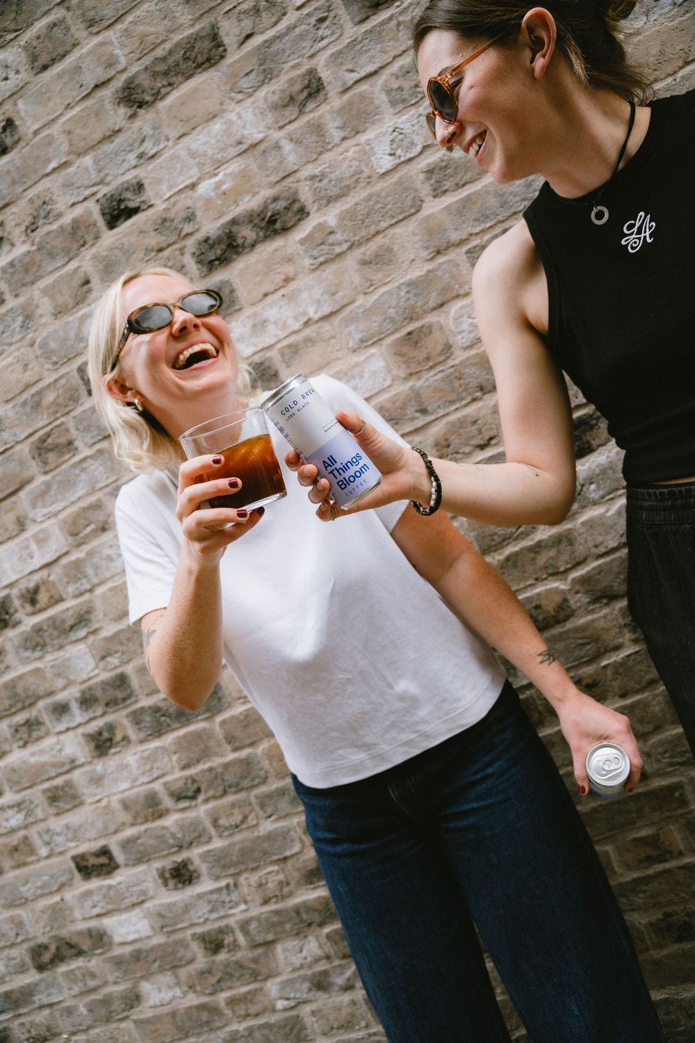 Lifestyle coffee photography in London showing two girls cheering with a delicious can of cold brew coffee by All things Bloom