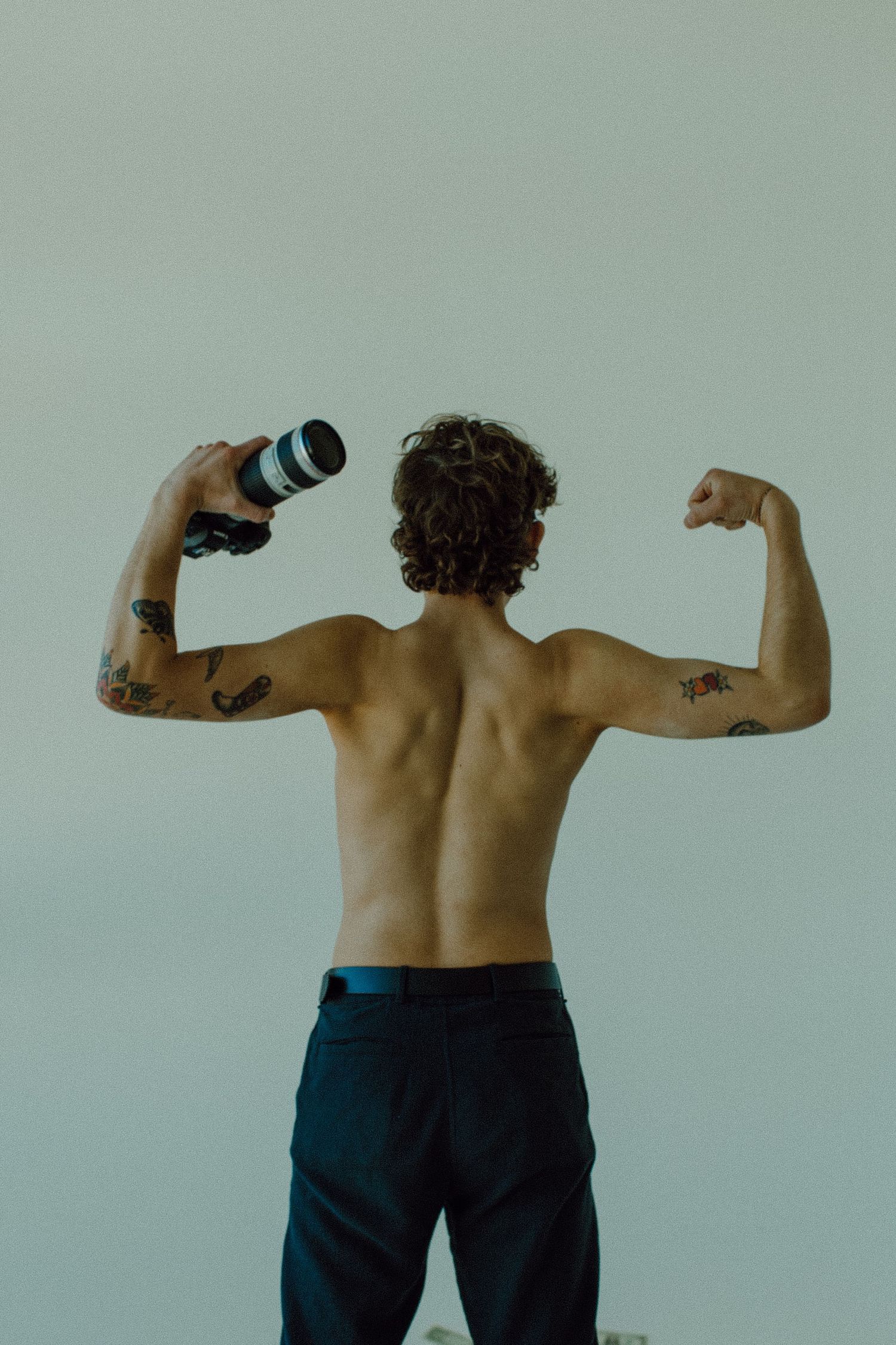 Gavin facing away from camera flexing his arms