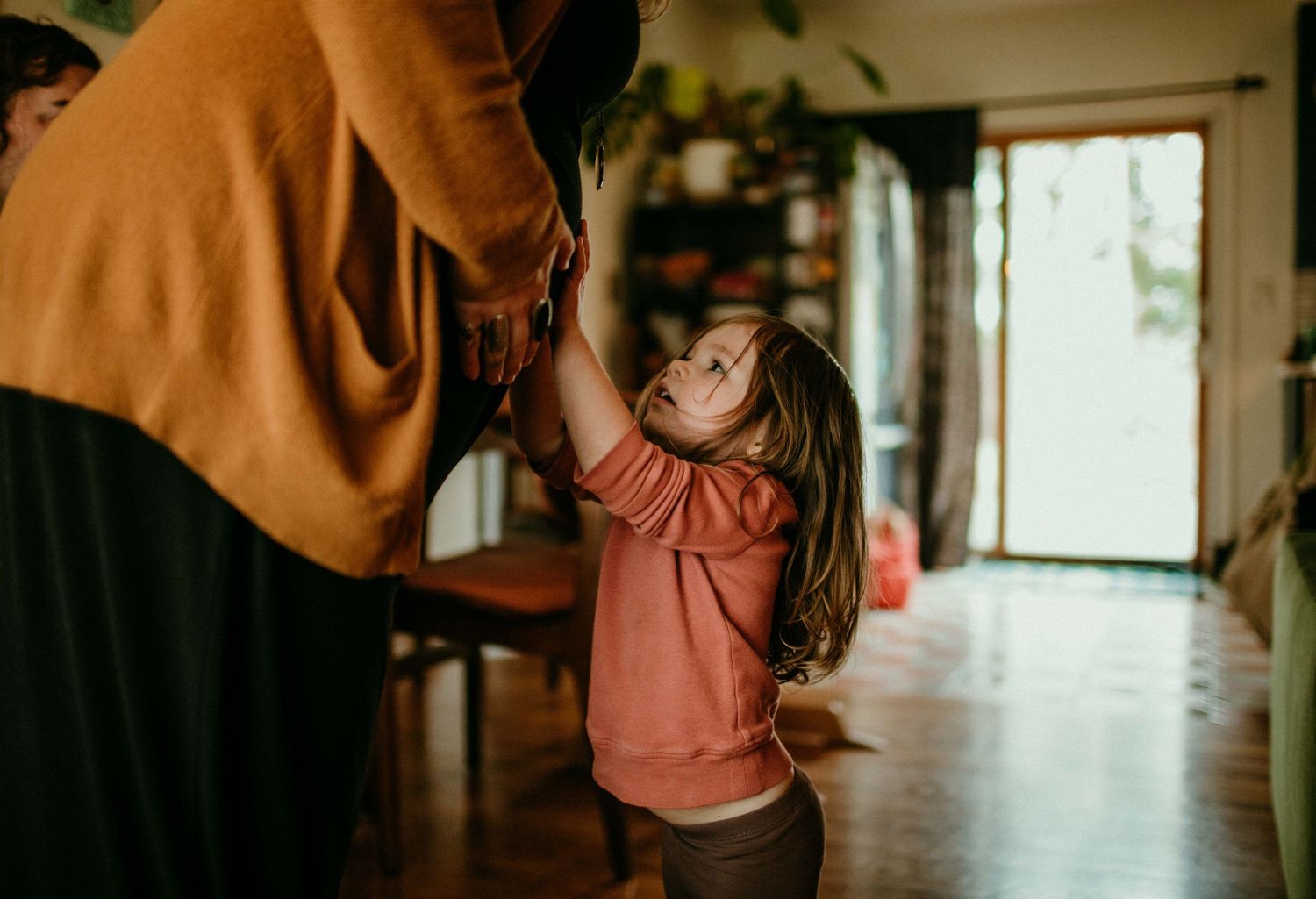 child is holding mom's pregnant belly and looking at it. portland oregon maternity photographer kimberly marie kimble