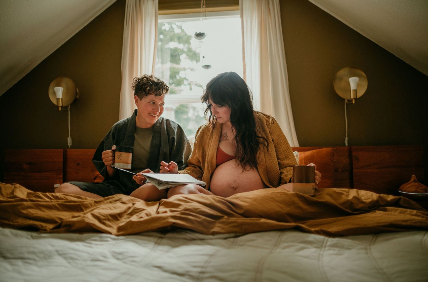 queer couple does a crossword puzzle in bed in-home documentary photography session portland oregon rushes & waves