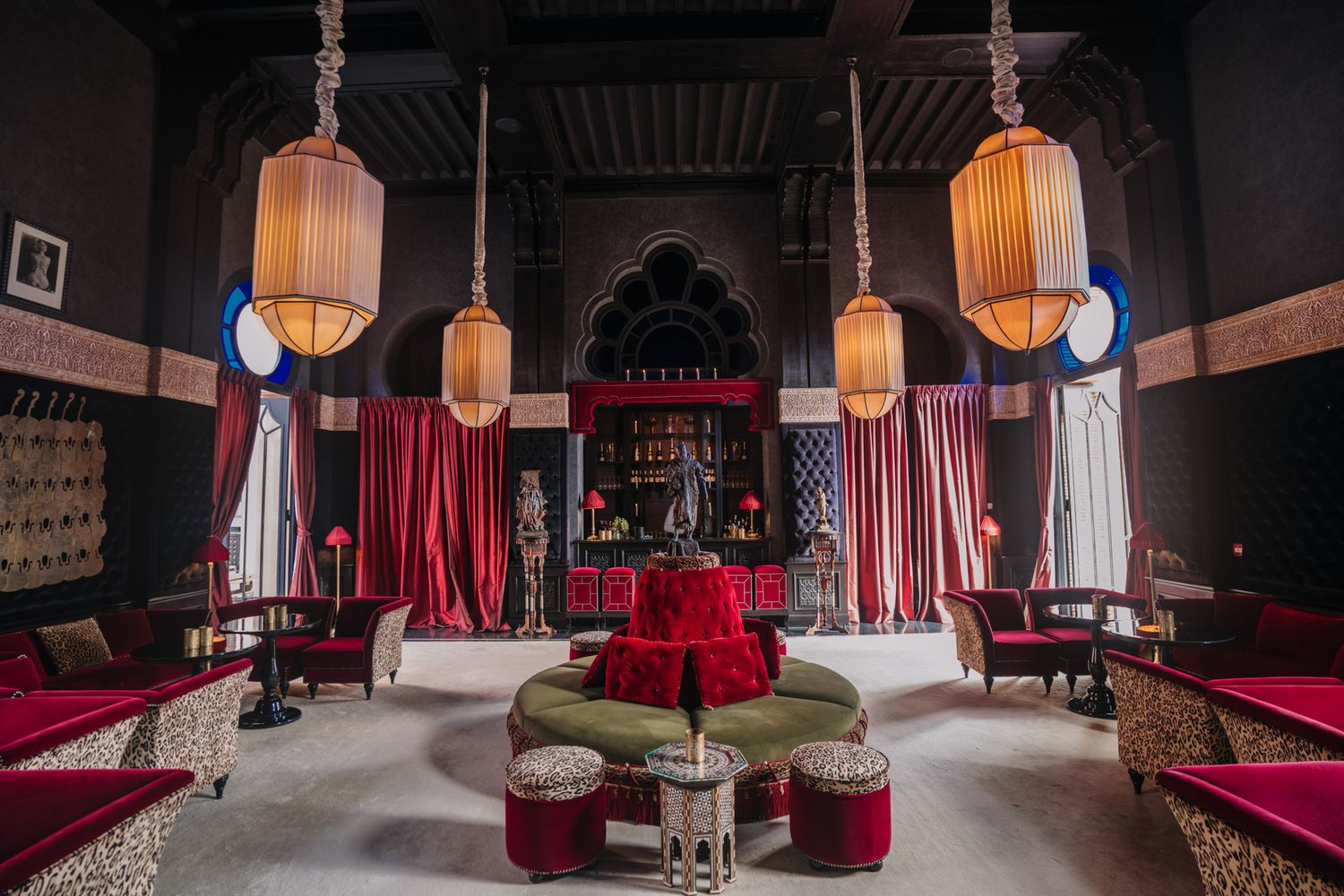 Oriental-style lounge with hanging lanterns, red velvet seating, and traditional decor.