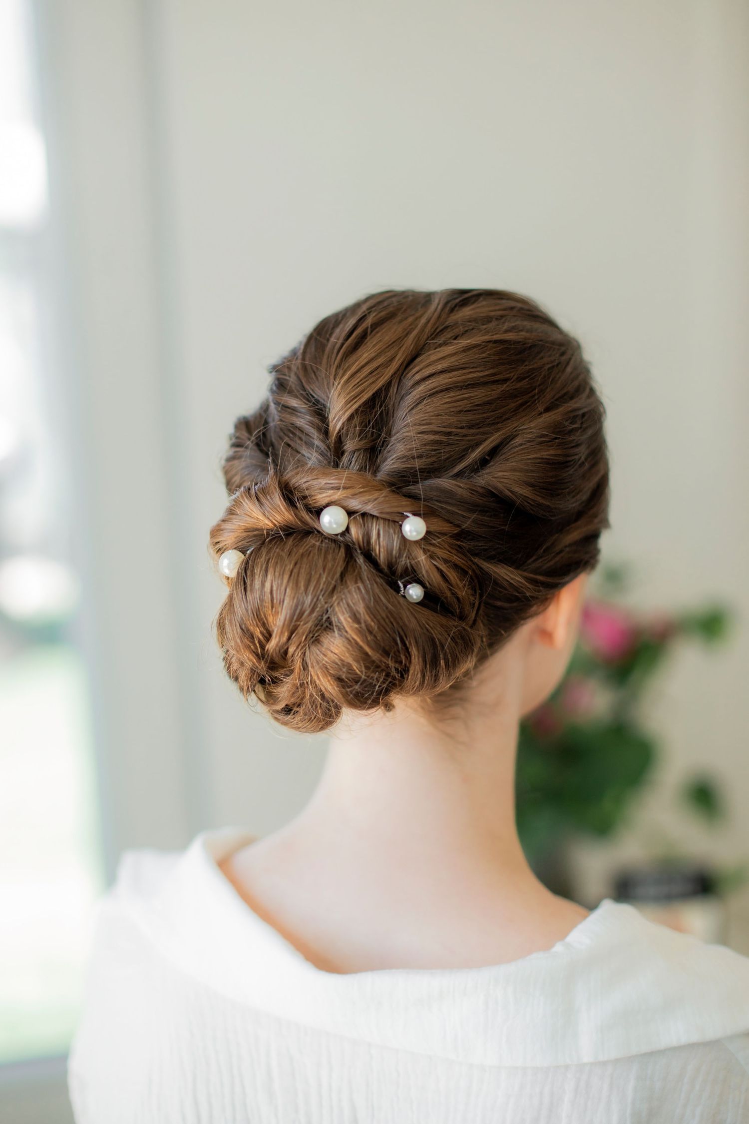 Elegant bridal updo with pearl pins showcased from behind.