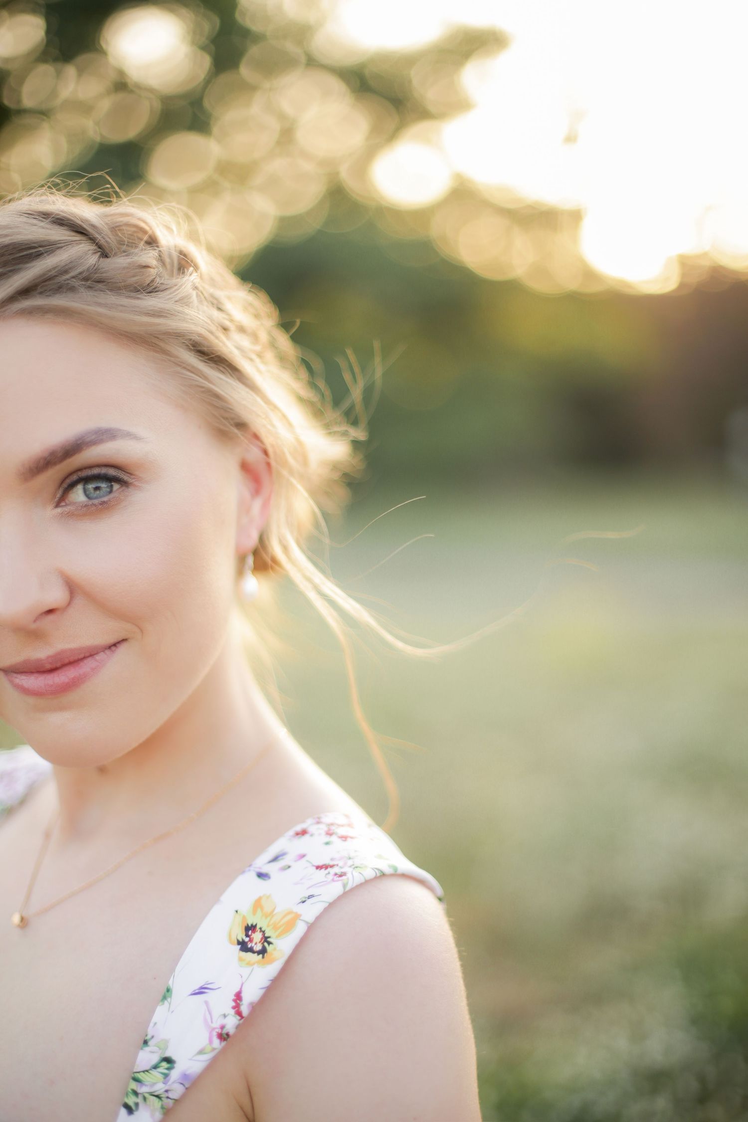 Soft portrait in golden hour light wearing a floral summer dress.