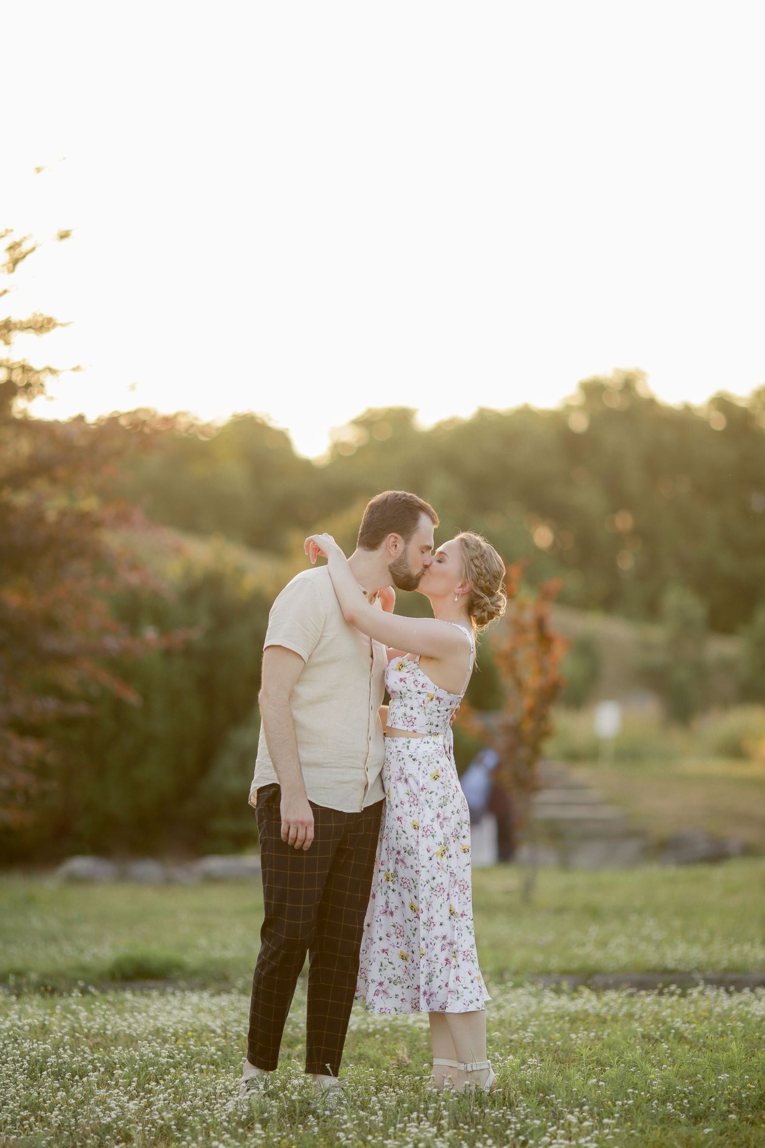 Romantic couple embracing in a sunlit garden during golden hour.