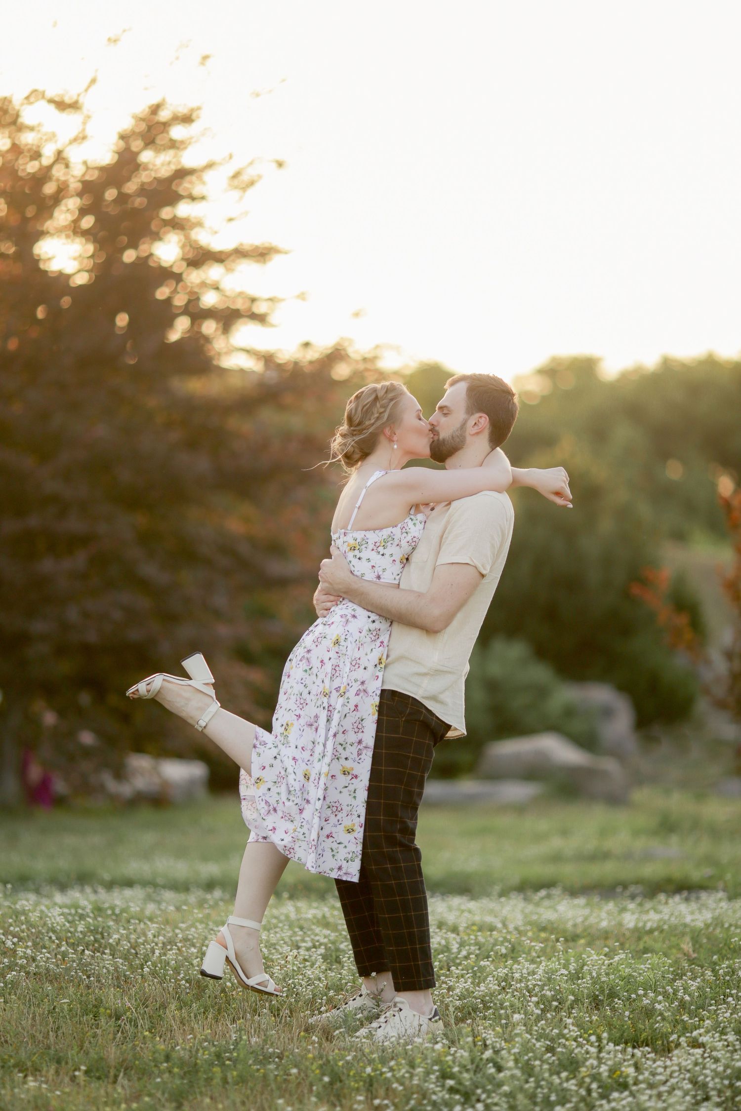 Joyful couple sharing a romantic moment in a garden at sunset.