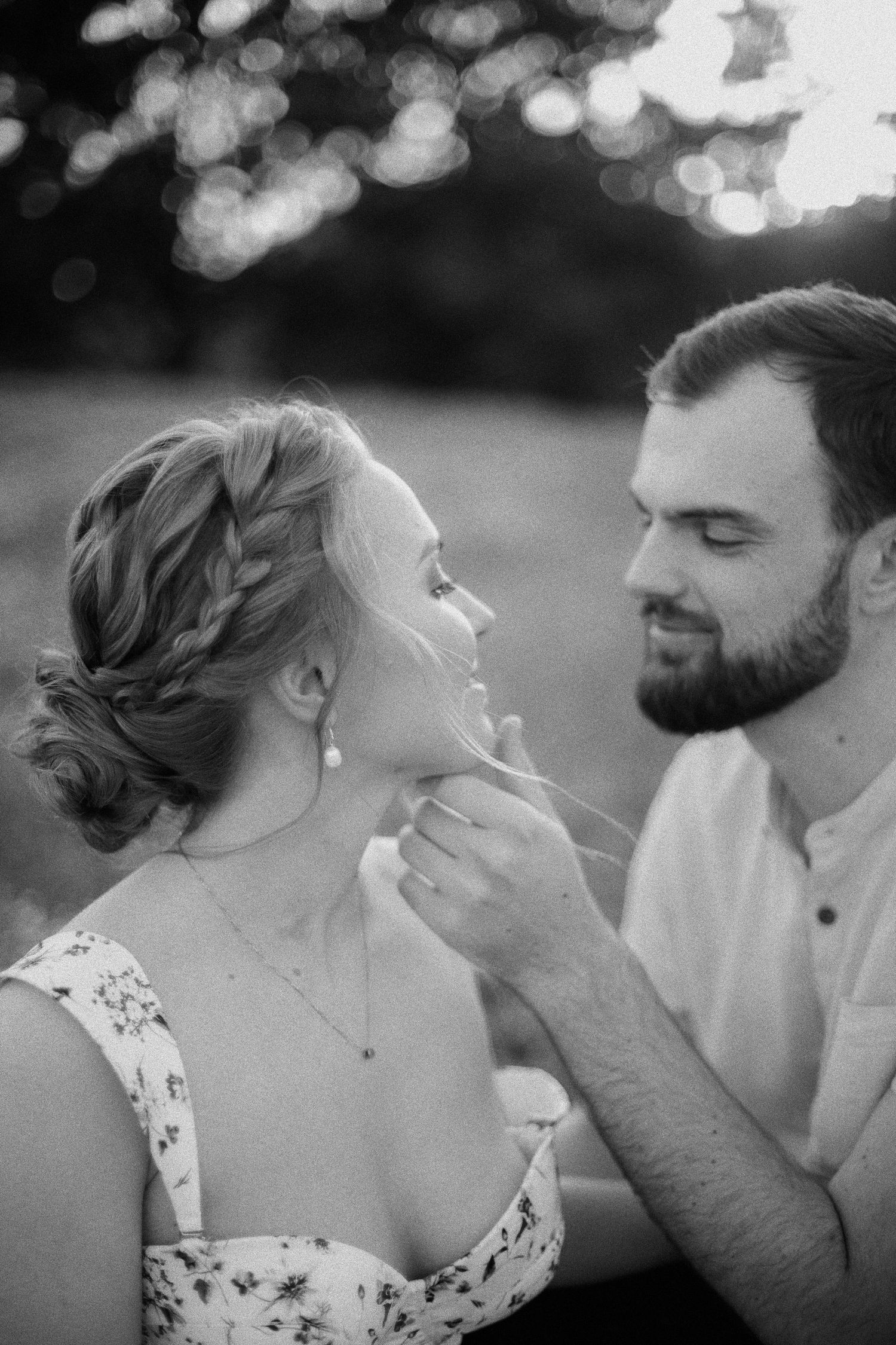 Black and white romantic portrait of couple sharing tender moment outdoors.