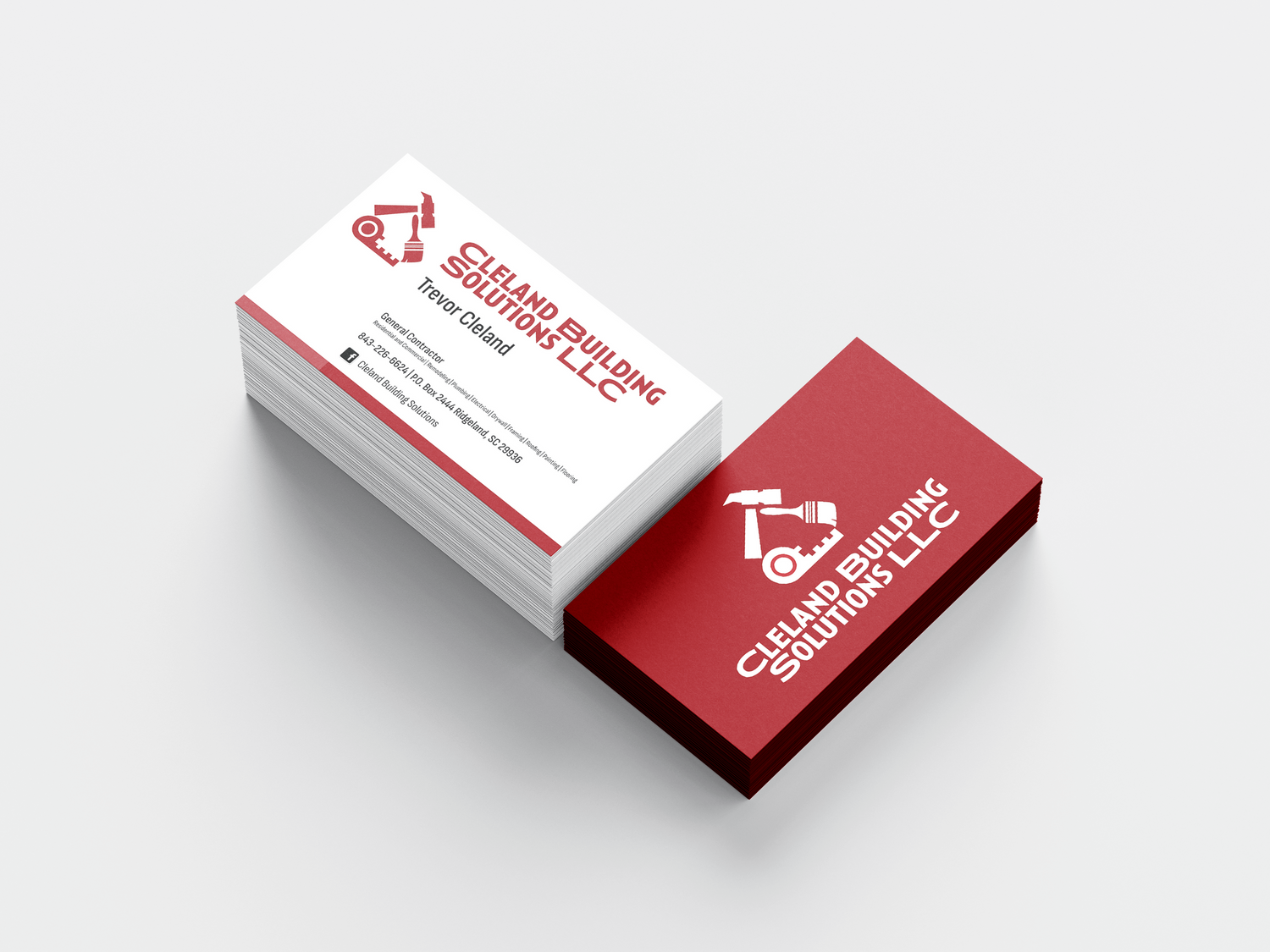 Stack of red and white business cards with construction company branding.