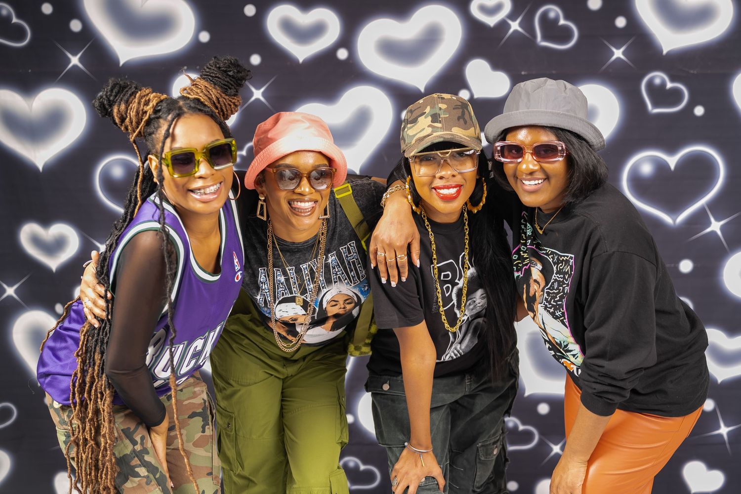 A group poses together against a backdrop of glowing heart designs.