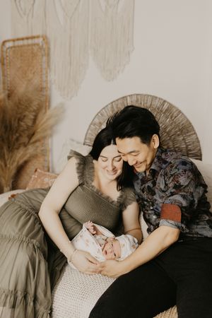 Artistic family photoshoot with neutral tones and soft lighting showing intimate moments.