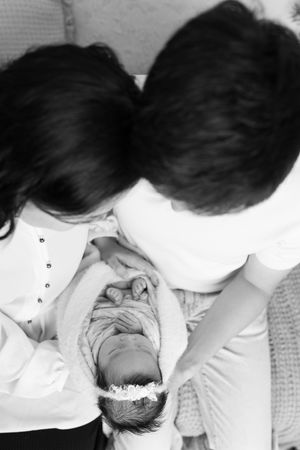 Black and white photo series capturing tender moments between parents and newborn.