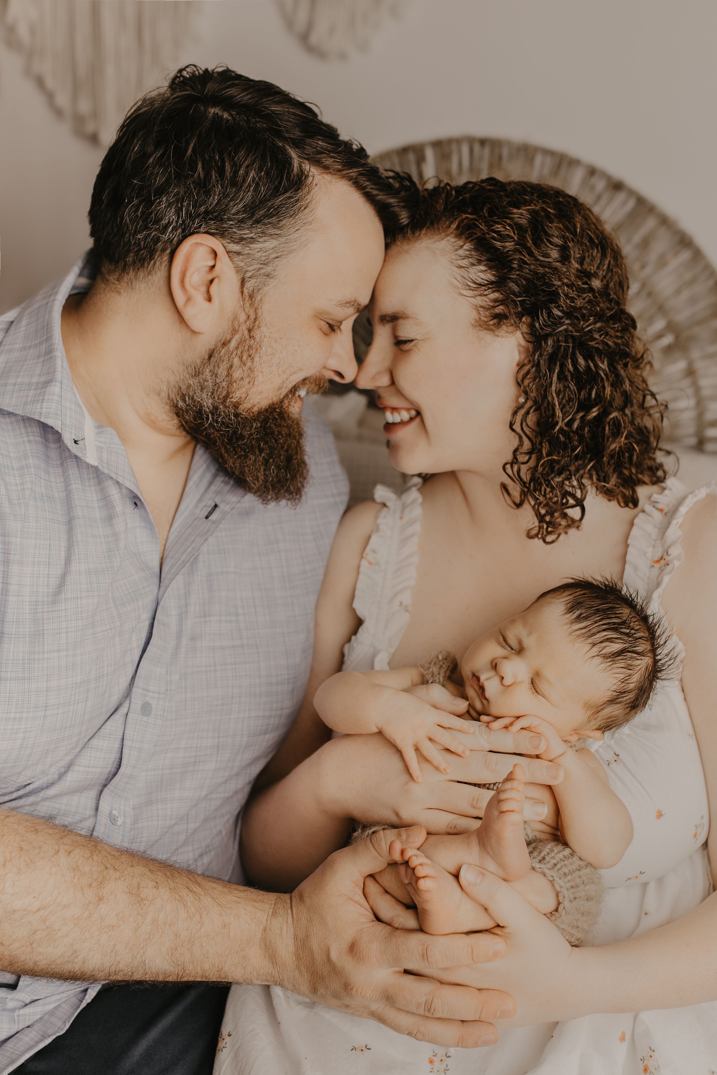 Intimate family moment captured in soft neutral tones during an indoor photo session.