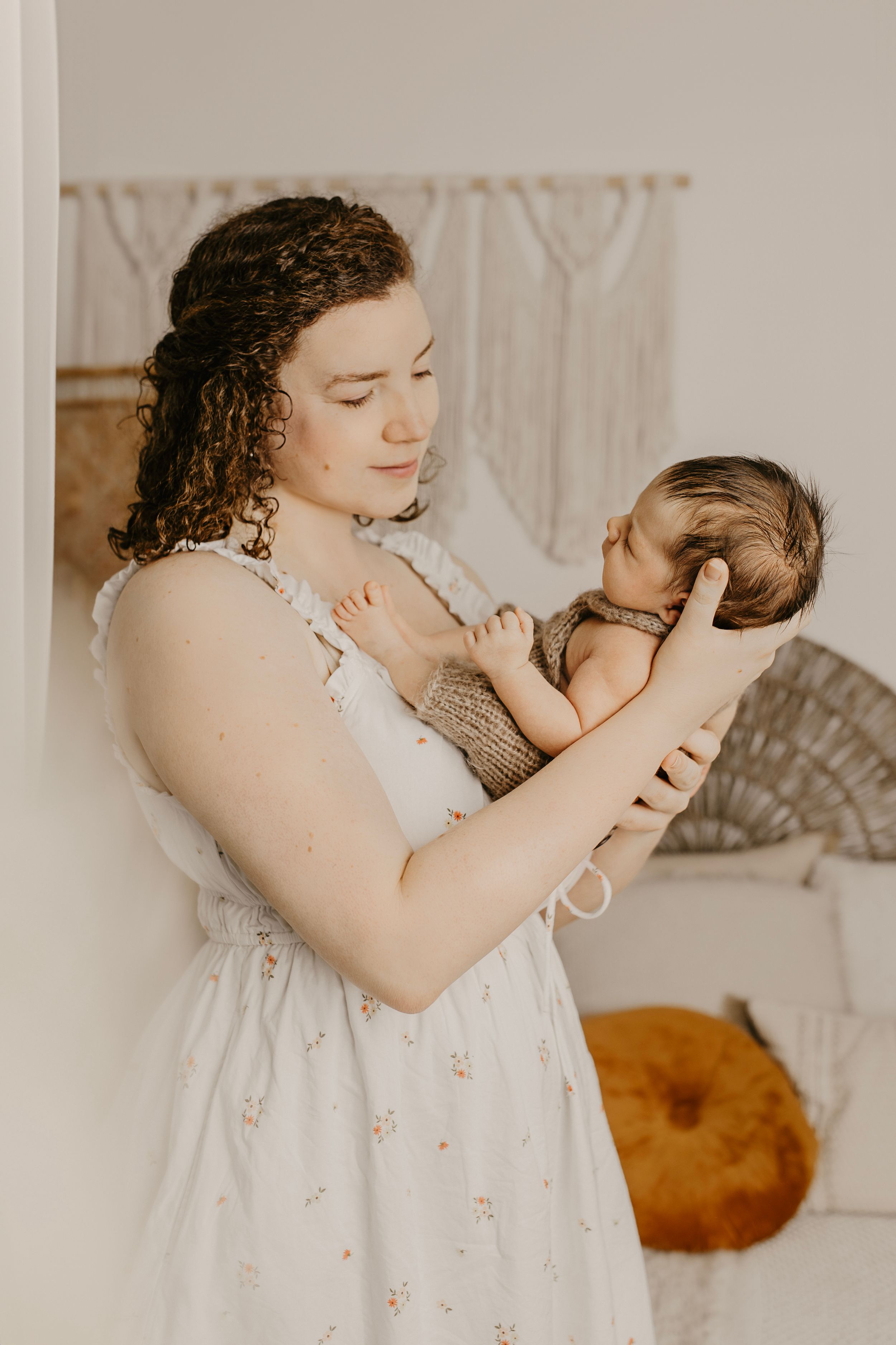 Intimate indoor family portrait with soft lighting and neutral colors.