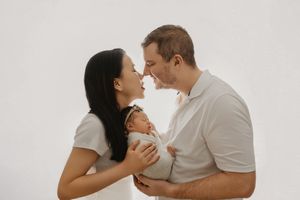 A couple in white outfits share intimate moments in a series of romantic poses against a light background.