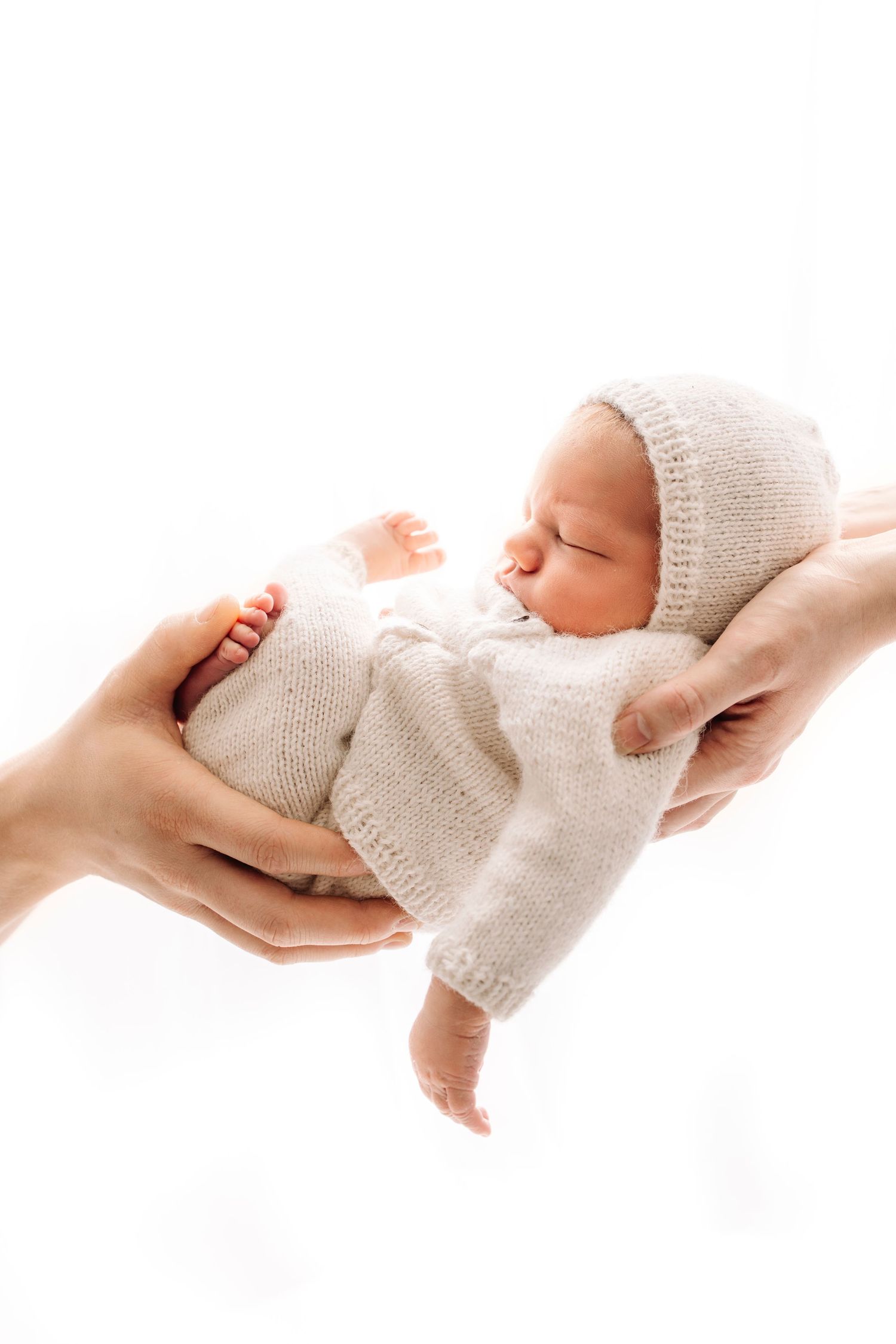 nyfødt baby I hjemmestrykket sett i hender til mamma og pappa