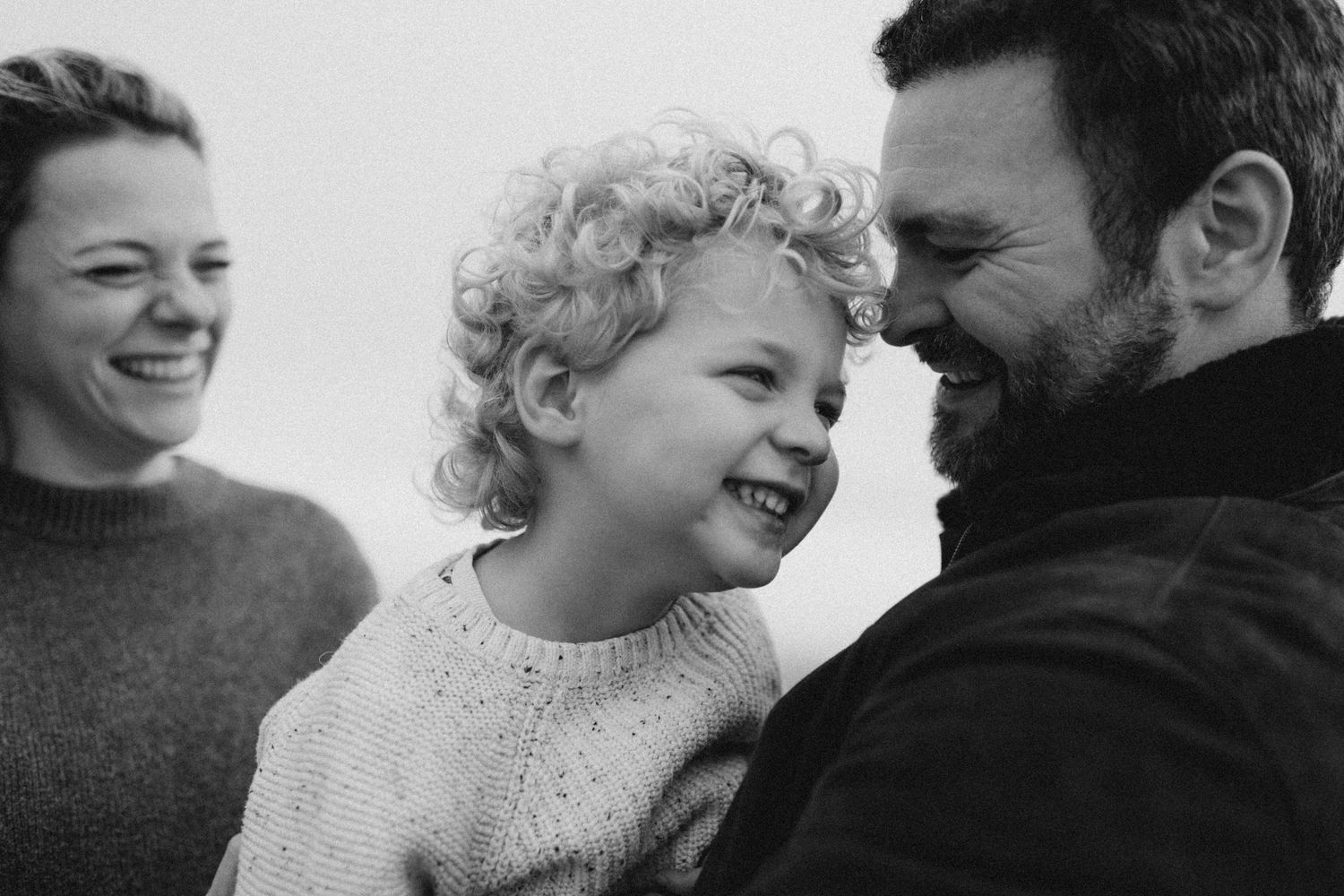 A young couple interacting lovingly with their young son during their family photo session in Kent