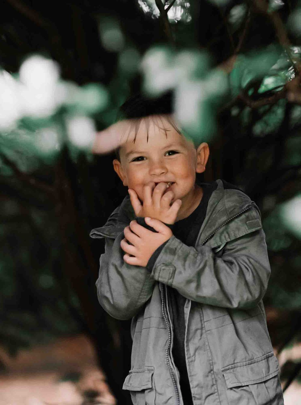 A child smiling amongst trees