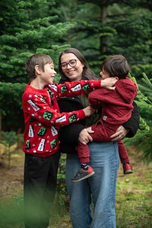 A mother tickles and laughs with her two sons at a Christmas tree farm in North Yorkshire.