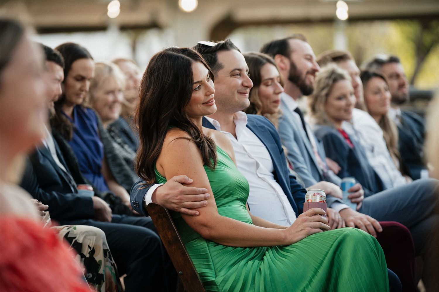 Wedding guests enjoying the ceremony while seated in formal attire.
