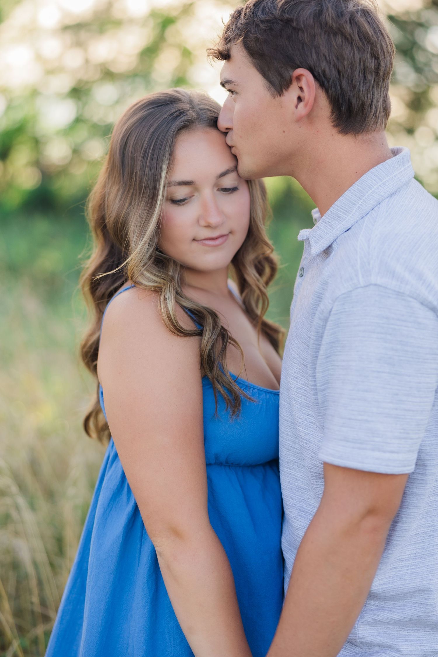A tender romantic moment between a couple outdoors in summer clothing.