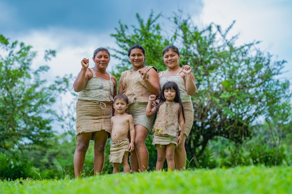 Group enjoying a sunny day outdoors in matching khaki outfits on green grass.