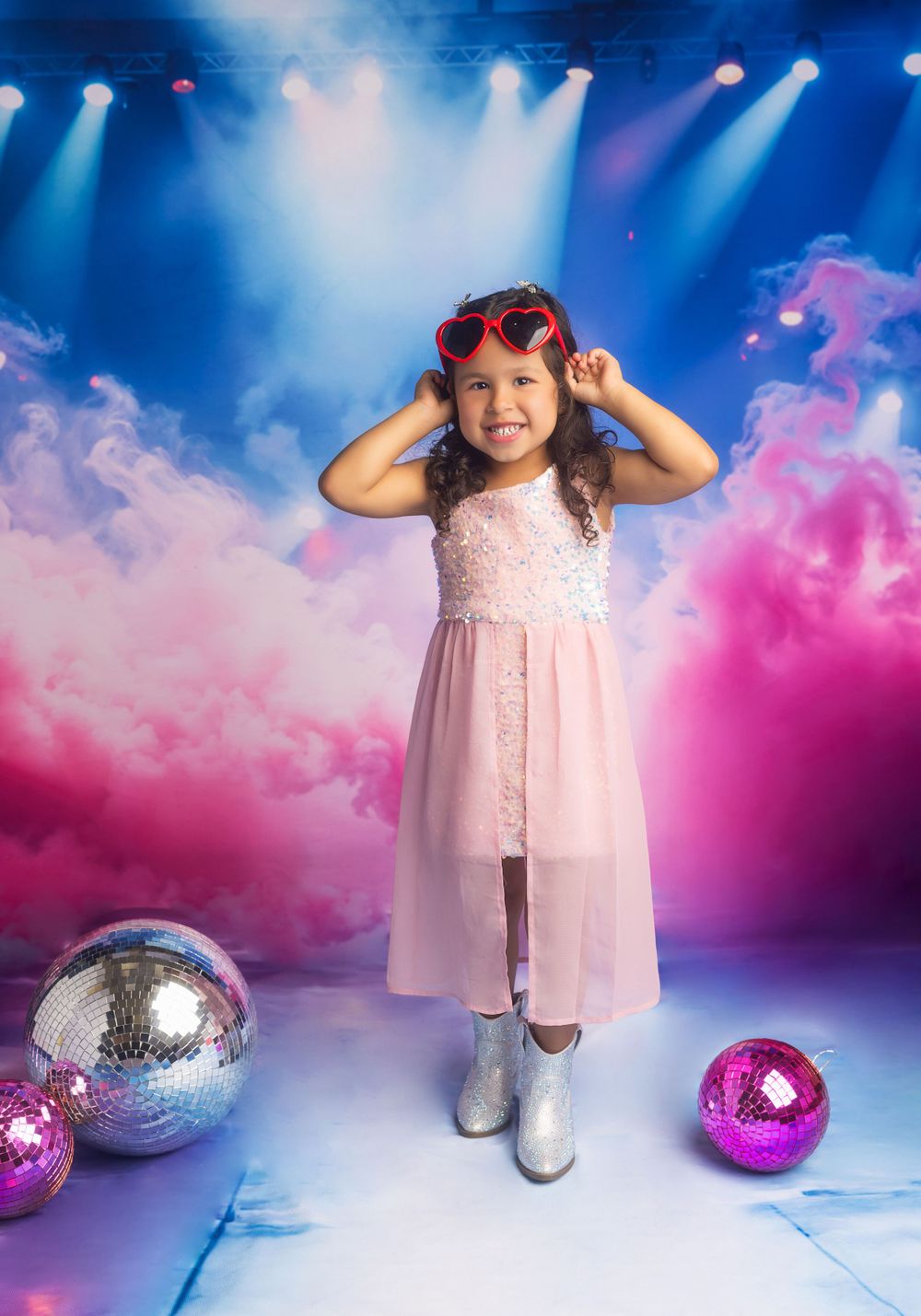Disco-themed photo setup with sparkly balls and pink smoke effects on blue background.