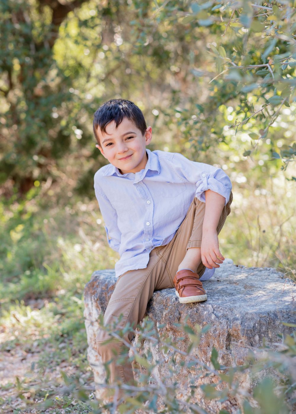 A light-blue collared shirt and khaki pants outfit worn in a sunny outdoor setting with natural greenery. Twin Creeks Mini Cedar Park, TX