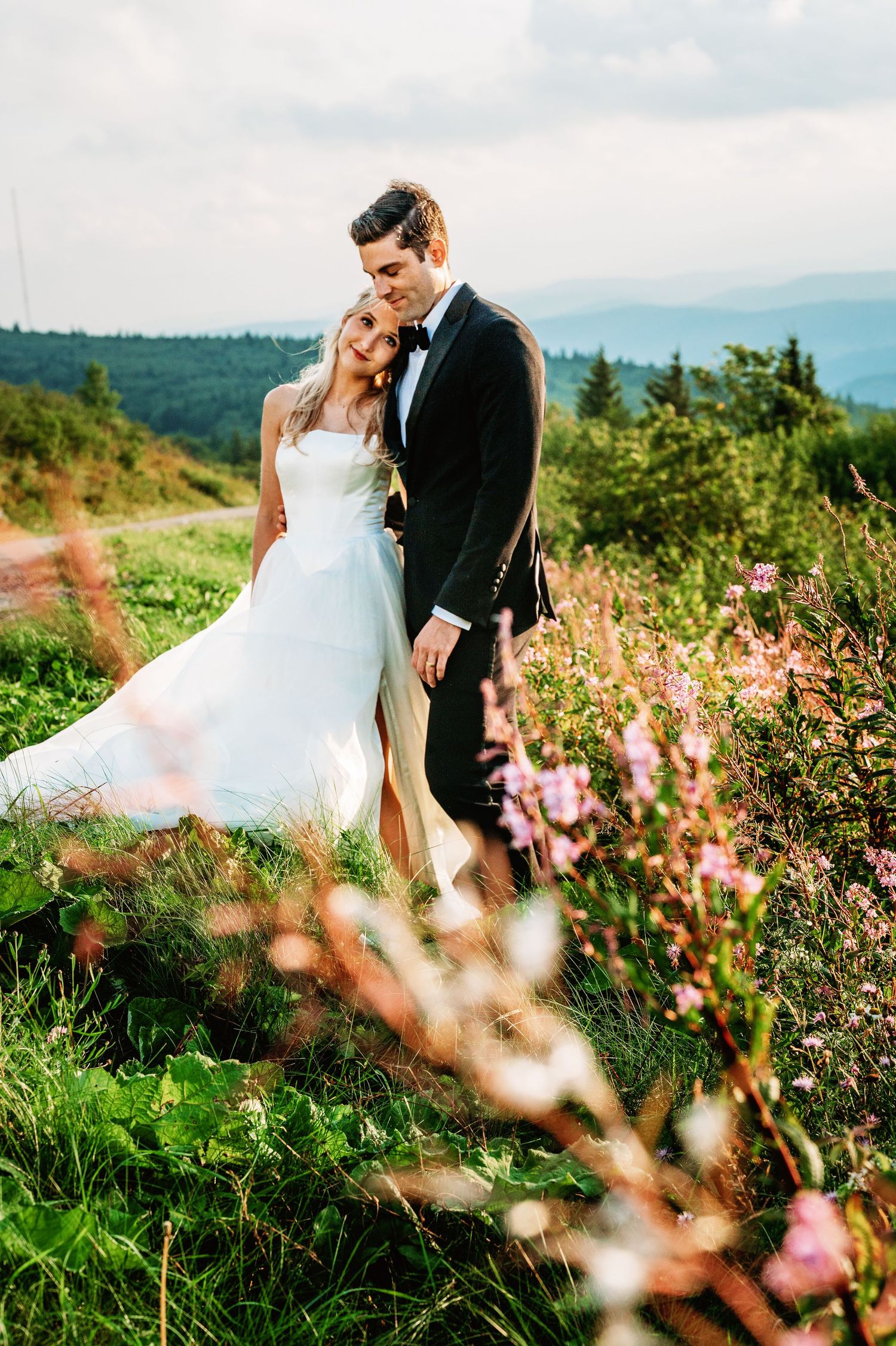 Bride and groom share a snuggle at sunset in the field of Spruce Knob Mountain during their elopement | west virginia elopement photographer