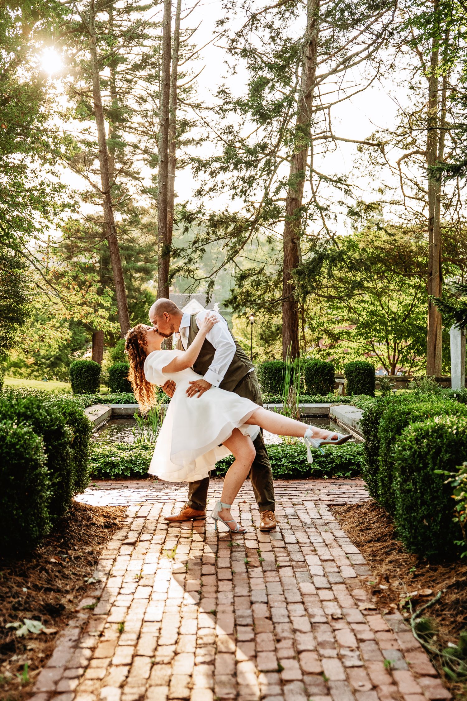 Bride and groom dip kiss in the garden at Highgate Carriage House | west virginia wedding photographer | fairmont wv