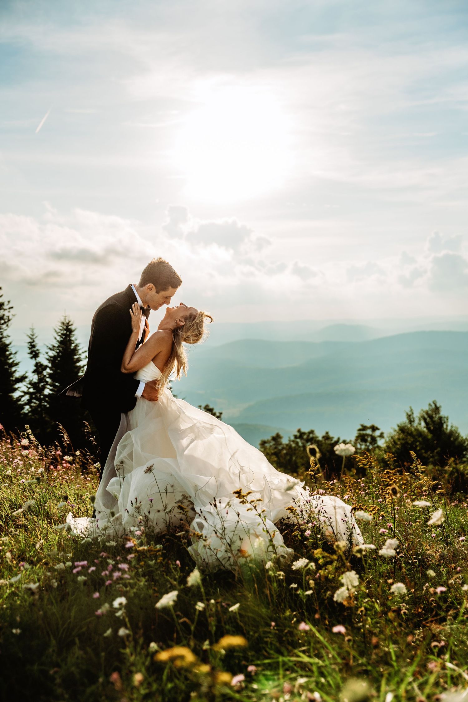 Bride and groom share a snuggle at sunset in the field of Spruce Knob Mountain during their elopement | west virginia elopement photographer