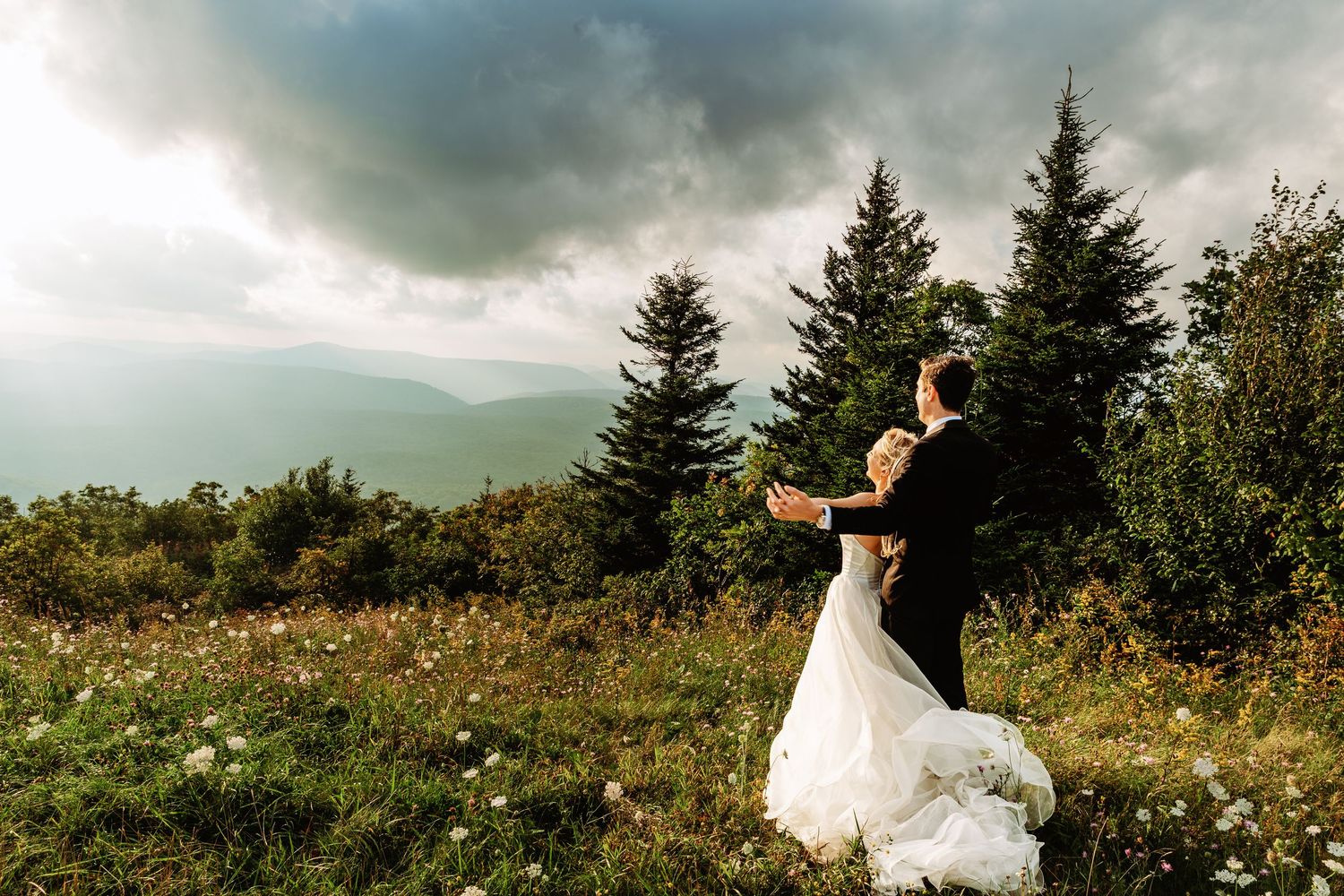Bride and groom share a snuggle at sunset in the field of Spruce Knob Mountain during their elopement | west virginia elopement photographer