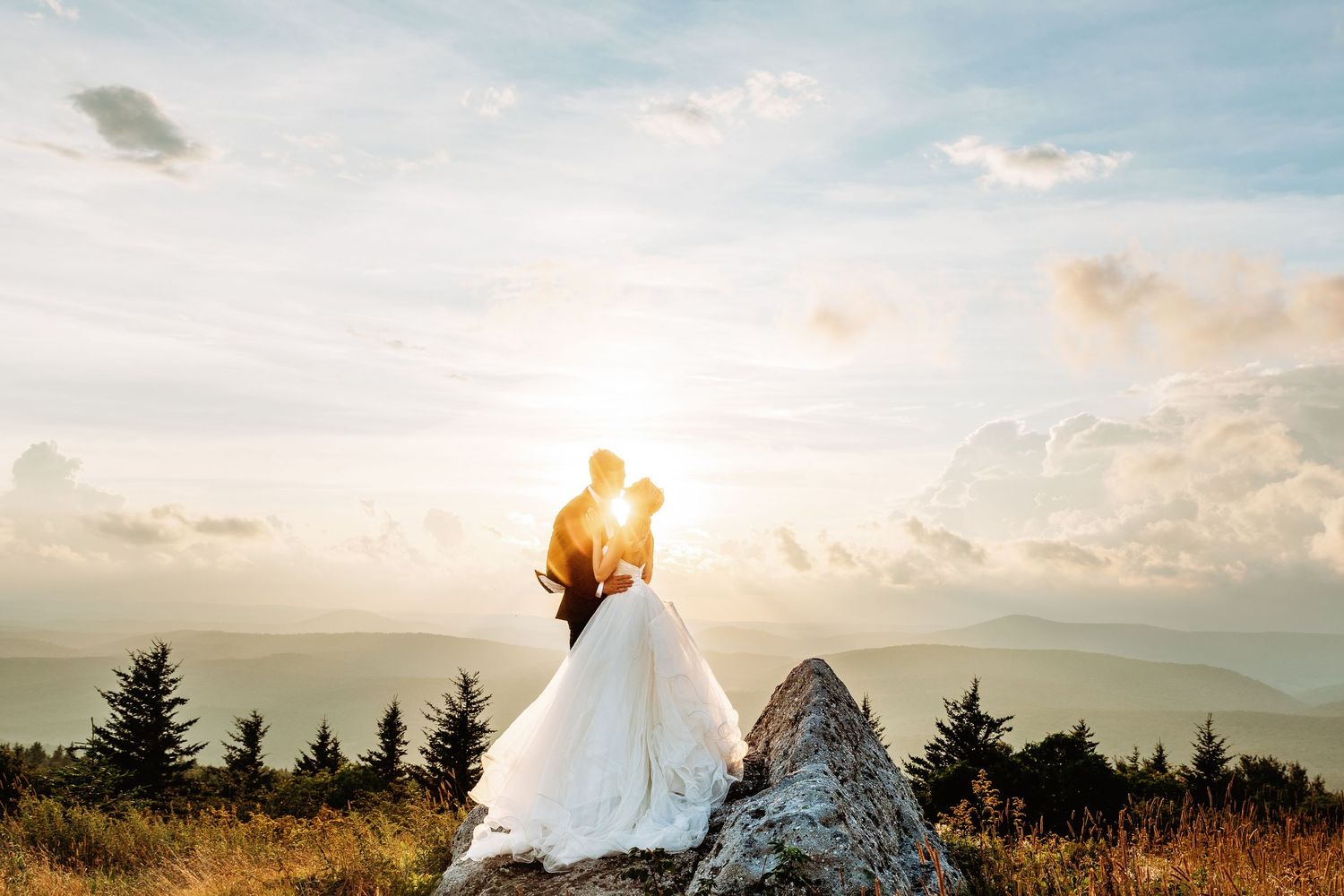Bride and groom share a kiss at sunset in the field of Spruce Knob Mountain during their elopement | west virginia elopement photographer