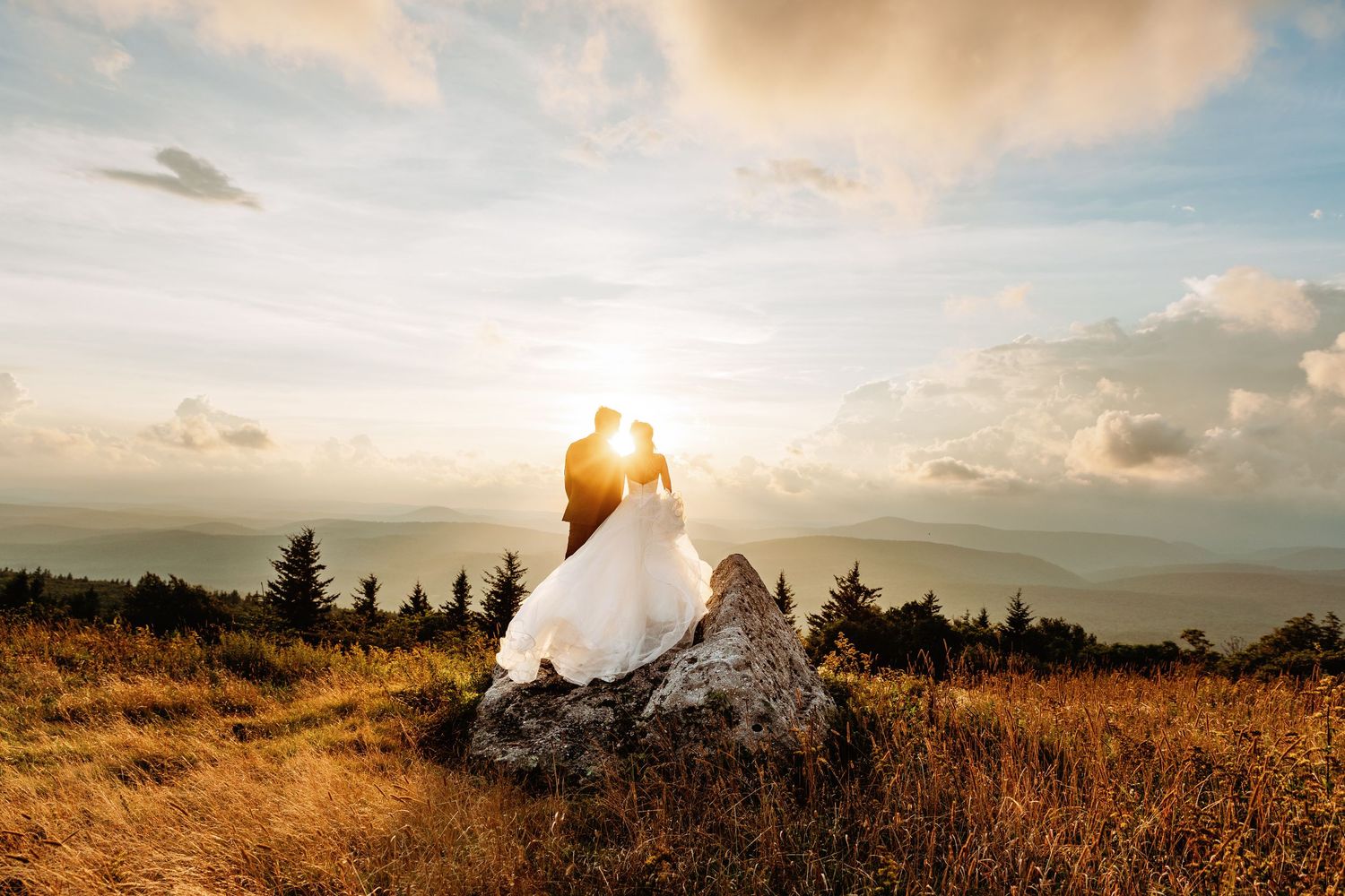Bride and groom share a kiss at sunset in the field of Spruce Knob Mountain during their elopement | west virginia elopement photographer