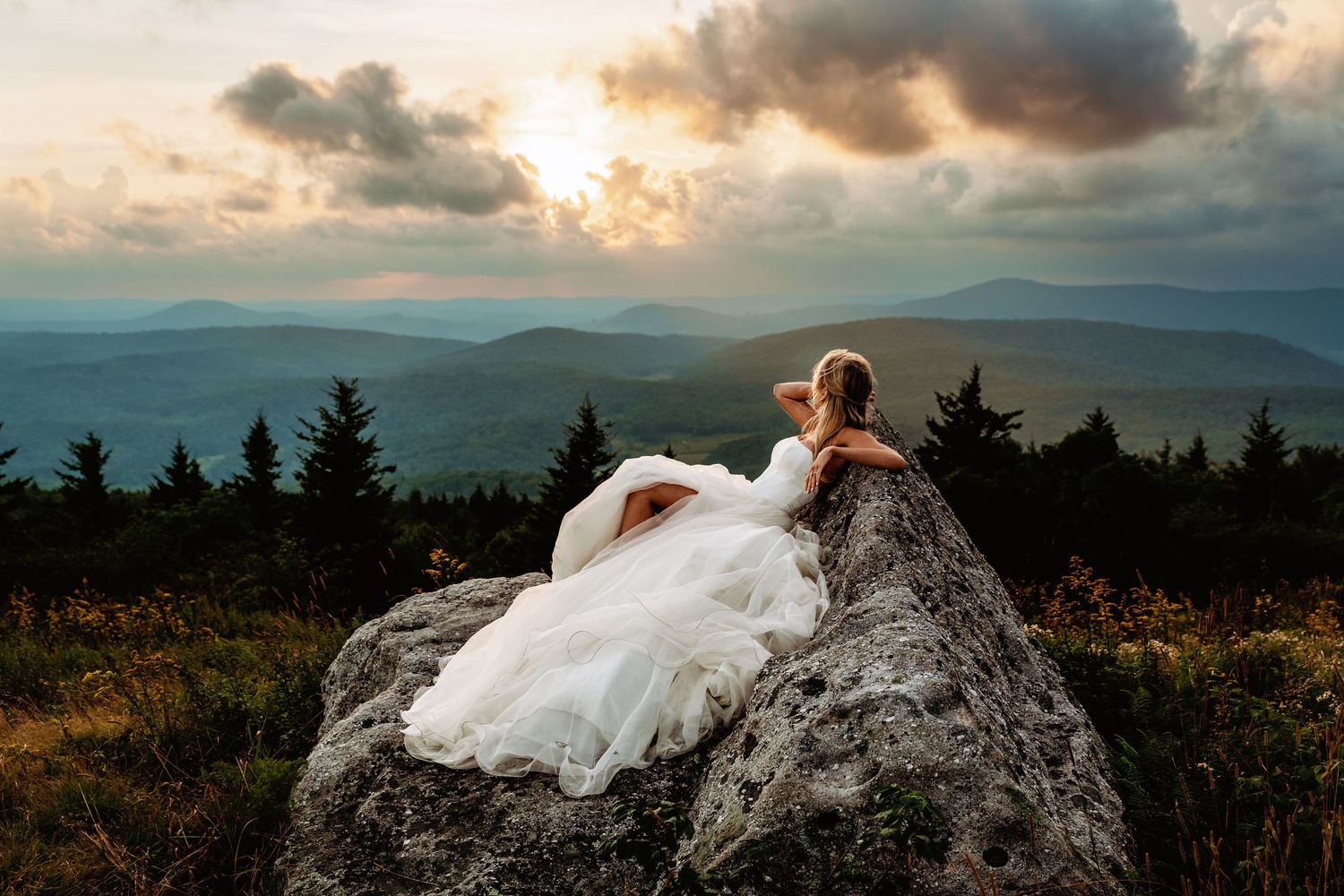 Bride enjoys the view at sunset in the field of Spruce Knob Mountain during their elopement | west virginia elopement photographer