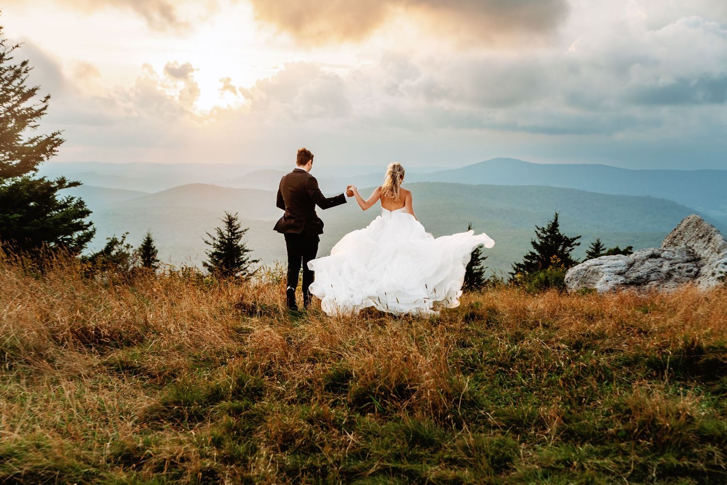 Bride and groom frolick at sunset in the field of Spruce Knob Mountain during their elopement | west virginia elopement photographer