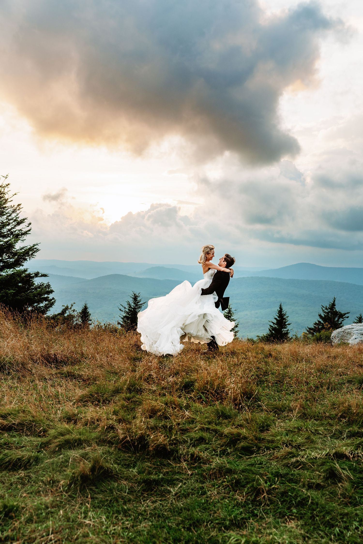 Bride and groom share a kiss at sunset in the field of Spruce Knob Mountain during their elopement | west virginia elopement photographer
