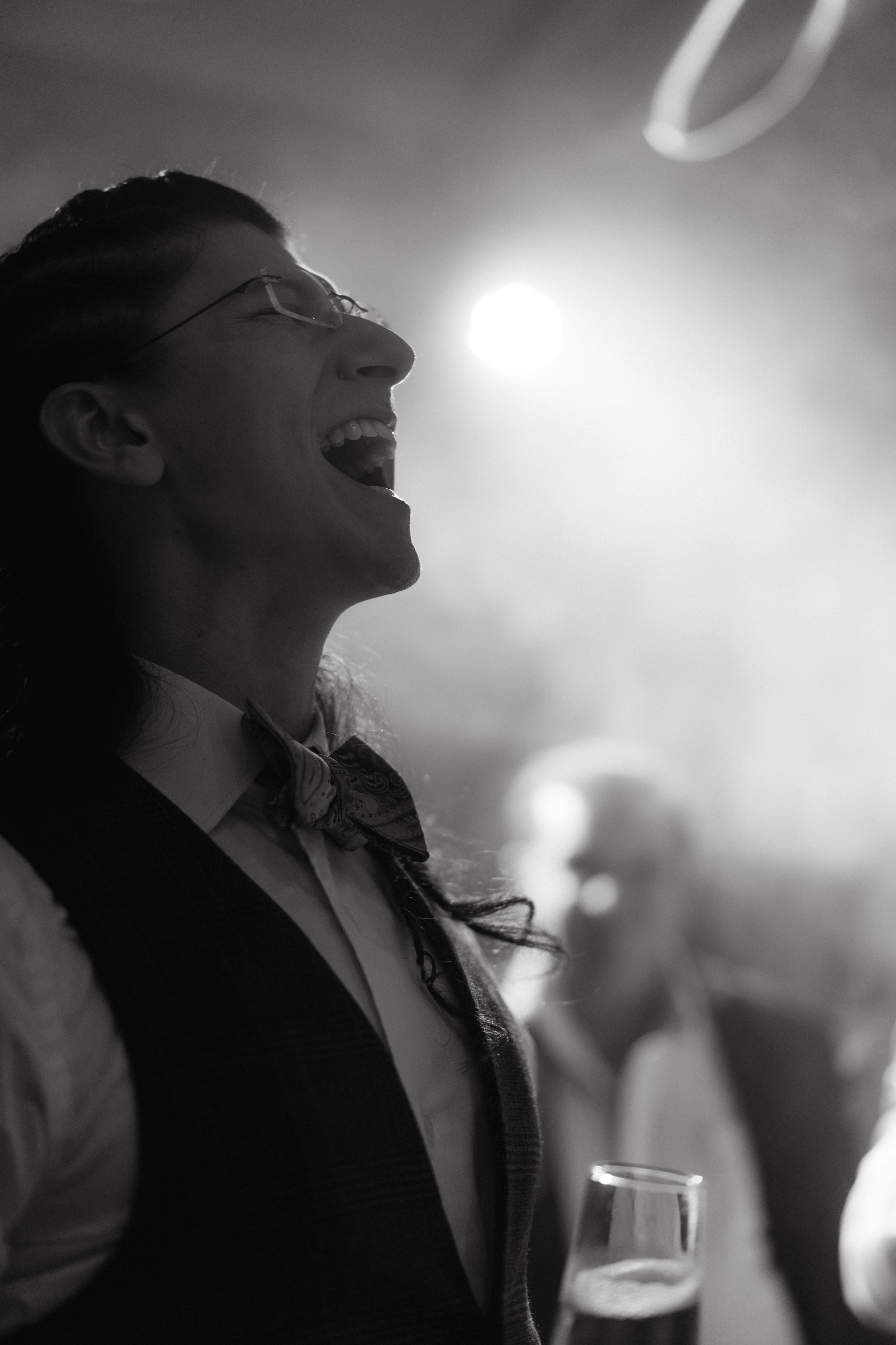 Black and white photo capturing laughter and joy during a celebratory moment.