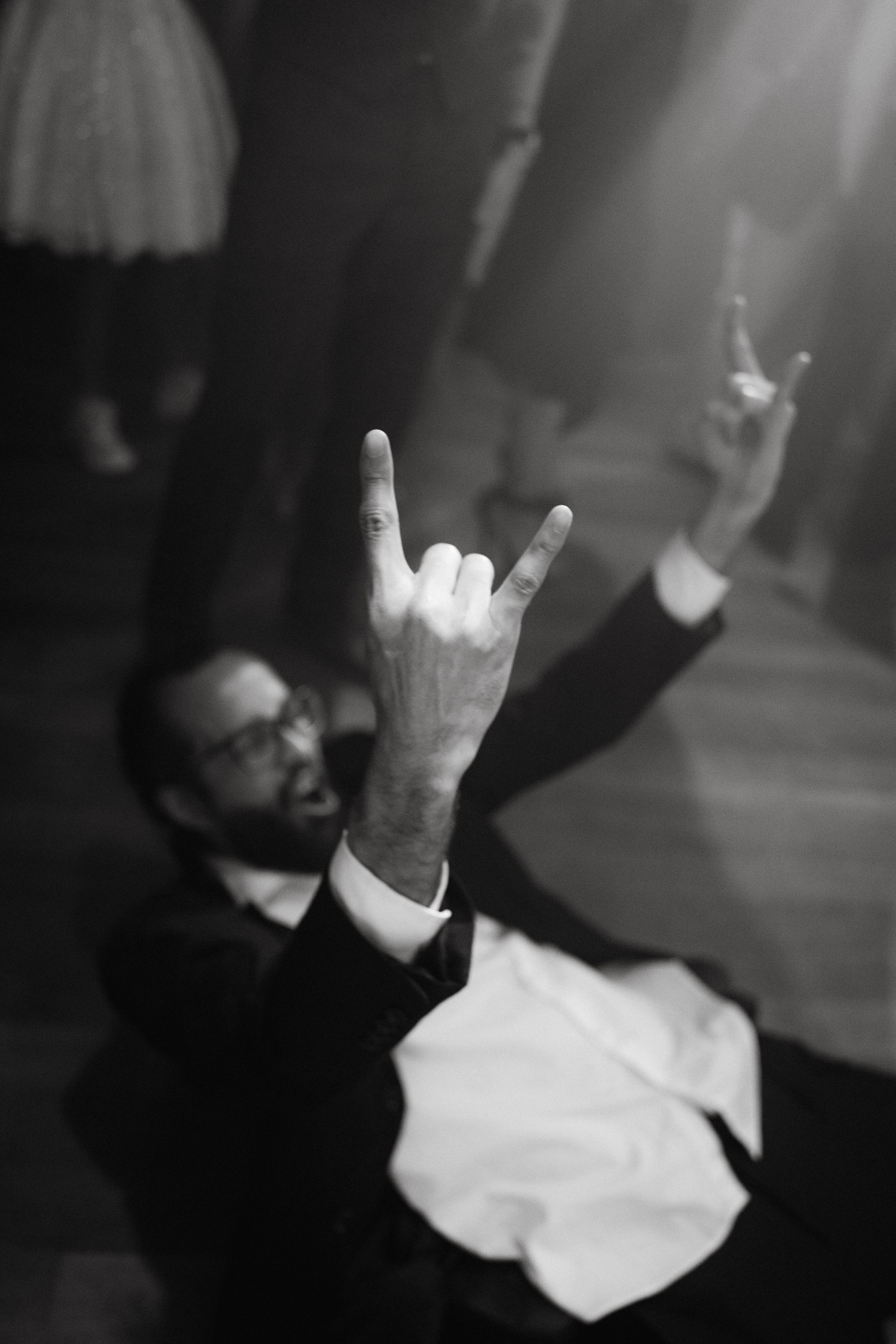 Black and white photo of hands raised in celebration during a party.
