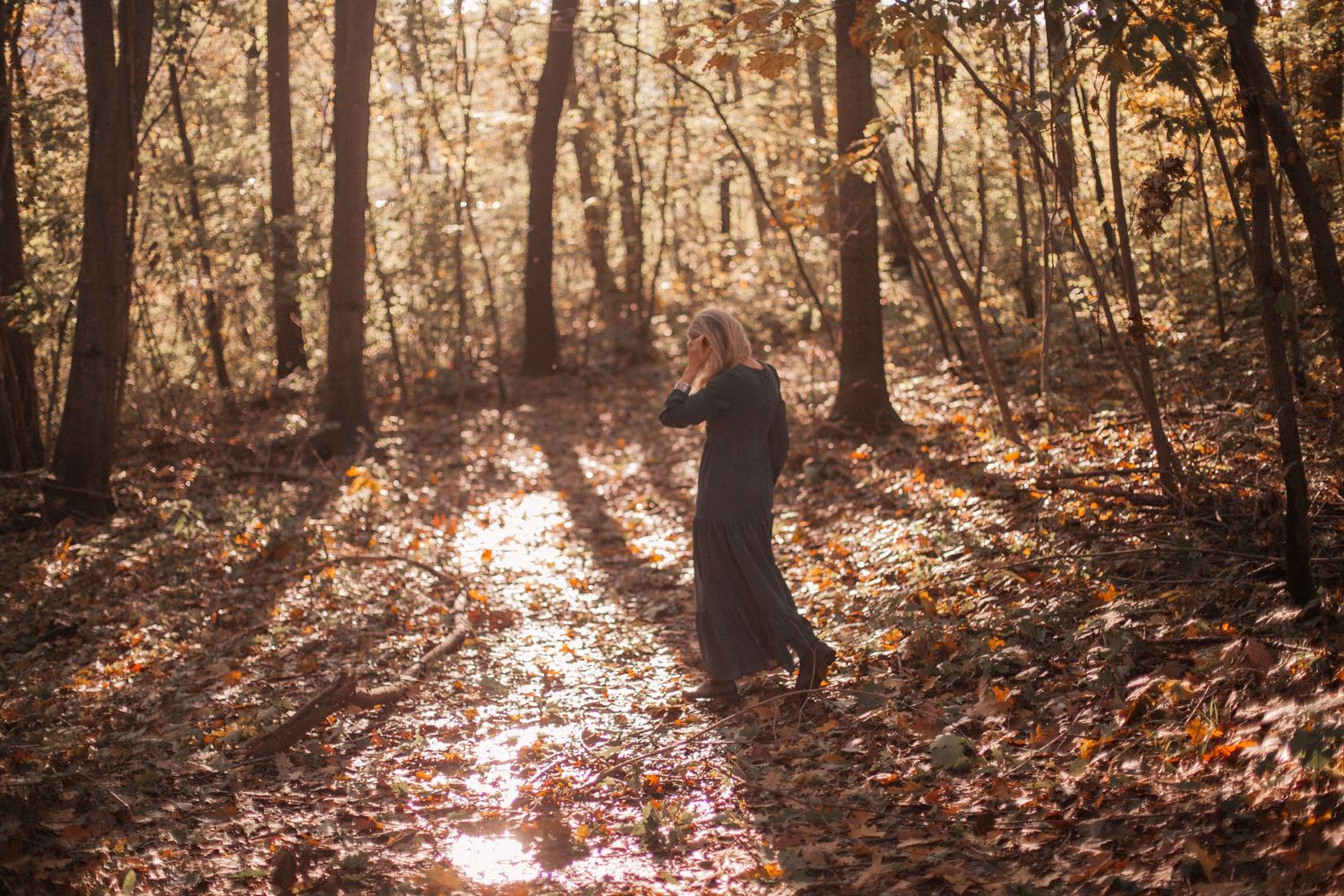 donna vestito lungo cammina in un bosco, alberi alti, foglie colorate a terra, sessione autunno, sessione ritratto personalizzata Osnago