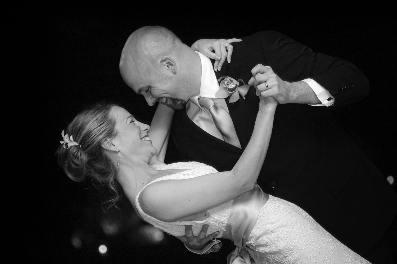 A dramatic black and white dance photo showing a couple in an intimate dip pose.