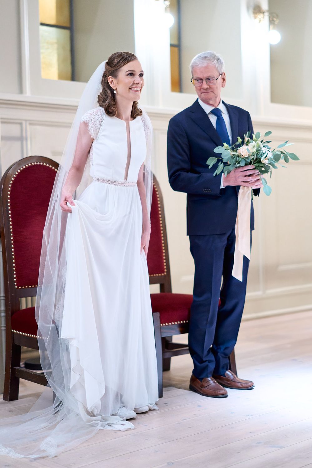 An elegant wedding ceremony setup with a white gown and floral bouquet in a formal setting.