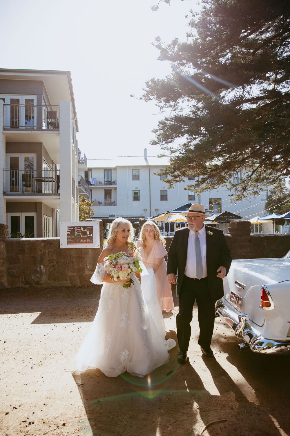 A sequence of wedding party photos taken outdoors in bright sunlight showing silhouettes against white buildings.