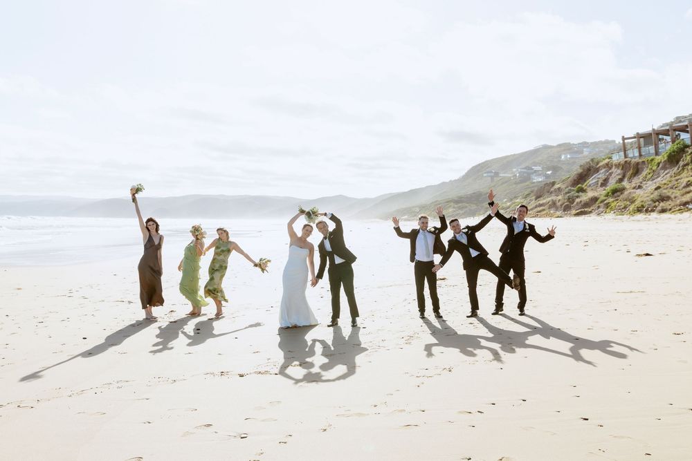 A sequence of silhouettes cast on a sandy beach shows people jumping and playing in the sunlight.